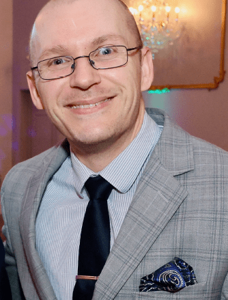 Man in glasses wearing a gray suit.