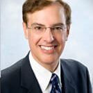 Professional headshot: smiling man in suit