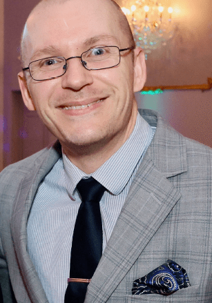 Man in glasses wearing a gray suit.