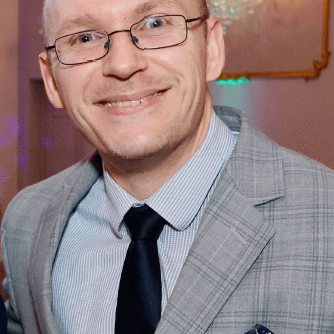 Man in glasses wearing a gray suit.