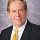 Professional headshot of person in yellow tie