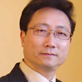 Headshot of man wearing glasses and suit