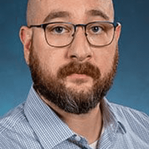 Bald man with glasses and beard.