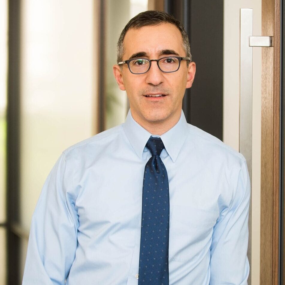Business professional wearing glasses and blue tie
